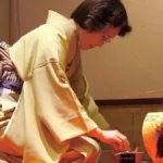 Tea ceremony with cello performance in traditional setting, soft lighting, cultural fusion.