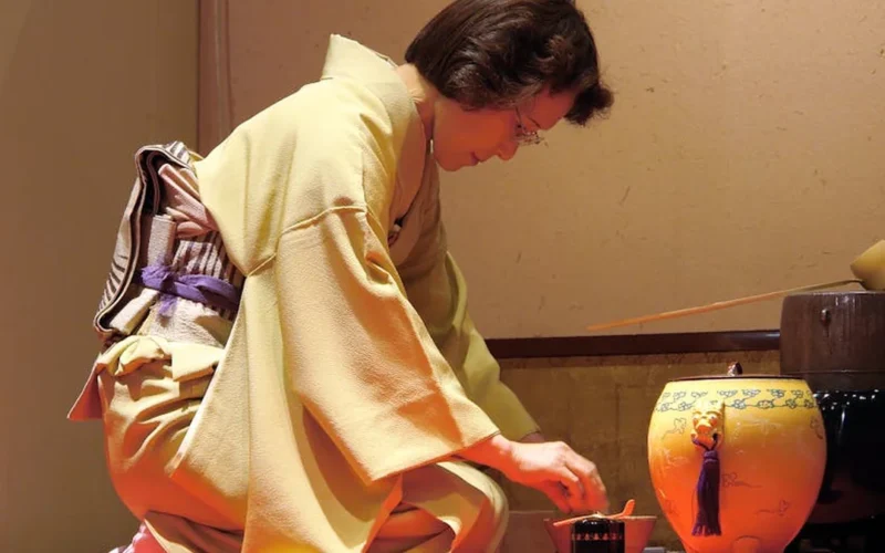 Tea ceremony with cello performance in traditional setting, soft lighting, cultural fusion.