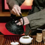 Pakistani designer enjoying tea in a traditional Indian home with vintage crockery and steam rising from a clay pot.