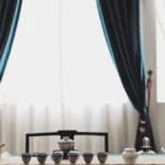 Amber tea liquid steaming in clay cup with wooden texture background under golden light.