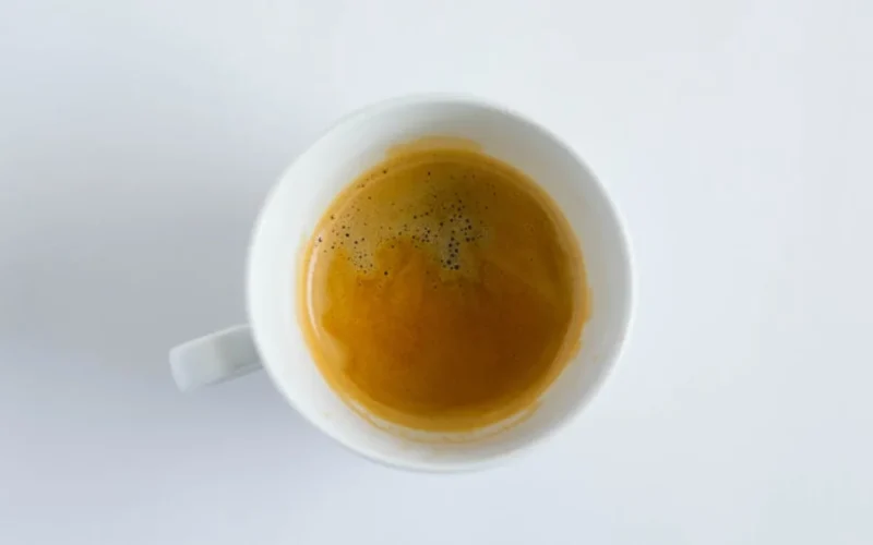 Vintage McDonald's coffee mug with dark roast beans and steam in a retro 1990s kitchen setting.