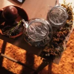 A jar of aged Lapsang Souchong tea leaves with mist rising in golden light.