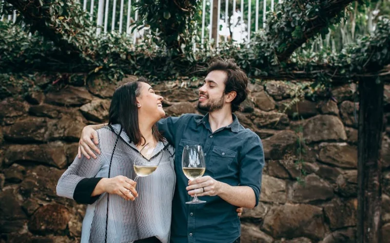 Vintage wine barrel in a rustic vineyard with family portrait and modern tasting room in the background.