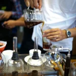 Coffee brewing in glass chamber with steam, modern kitchen setting.