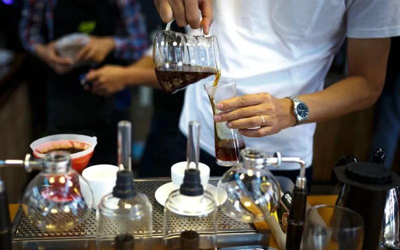 Coffee brewing in glass chamber with steam, modern kitchen setting.