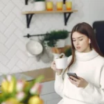 Smart coffee brewer brewing coffee in kitchen with glowing display and rising steam.