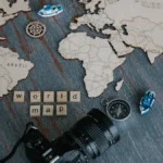Steaming decaf coffee cup with price tag on wooden table next to Colombia map with red pins.
