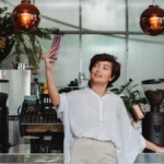Coffee influencer gestures over coffee cup in modern café with natural light