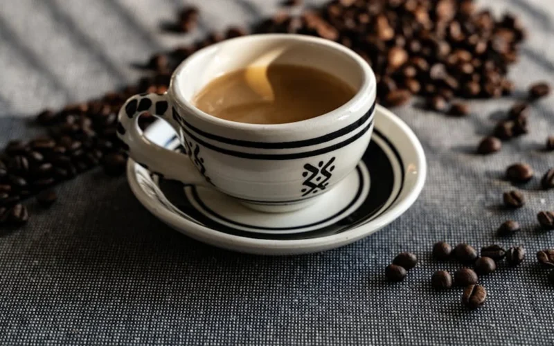 Defne Ceyda Okay pours coffee into a traditional Turkish cup in a minimalist setting with natural light.