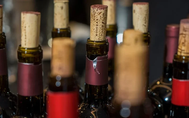 Sommelier pours wine into glass at stylish bar with soft lighting and focused expression.