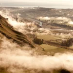 Sunset over Hawke’s Bay vineyards with gravel soils and wine bottles in the foreground.