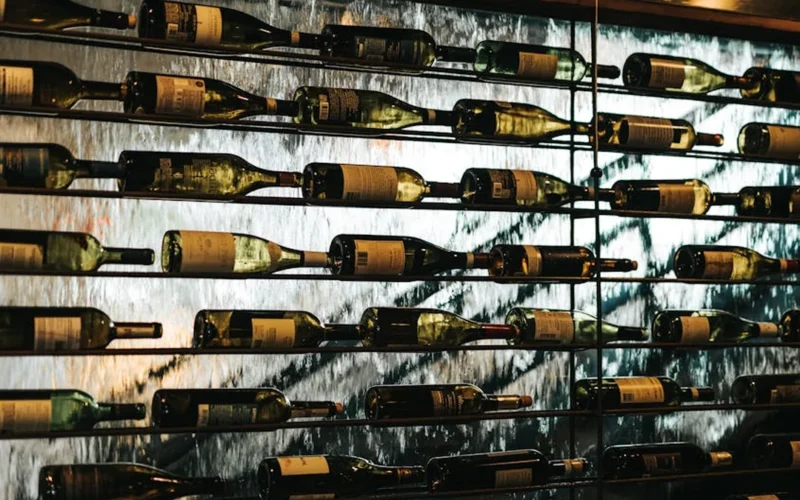 Elegant wine tasting room with wooden barrels and golden lighting.