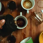 Coffee beans falling into a cup in an Italian café with warm lighting and wooden decor.
