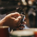 A high-end portable espresso machine brewing rich espresso into a dark cup on a clean surface.