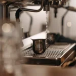 Barista meditates over coffee beans in minimalist café with soft lighting and calm expression.