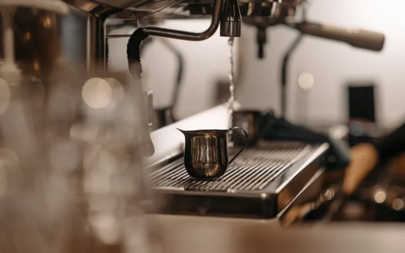 Barista meditates over coffee beans in minimalist café with soft lighting and calm expression.