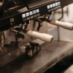 Rancilio Silvia espresso machine with PID control kit in use, steam rising from portafilter under warm lighting.