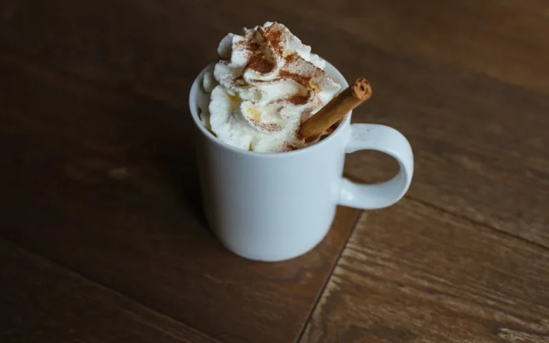 A steaming clay mug filled with chai using pre-blended spices, golden steam rising in warm lighting.