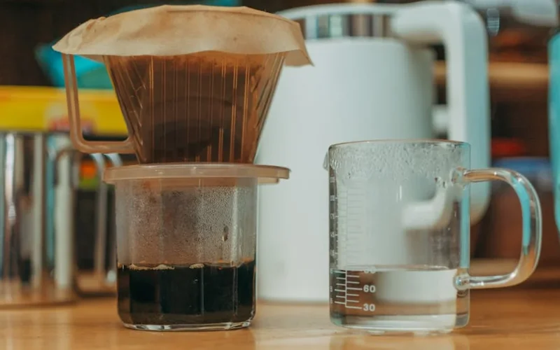 Sealed coffee bag showing condensation with steam rising in golden light.