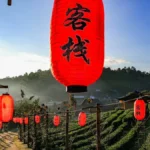 A traditional tea set with bamboo and lanterns under soft natural light.