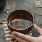 Young autumn pu er tea leaves swirling in clay teapot with steam rising under golden light.