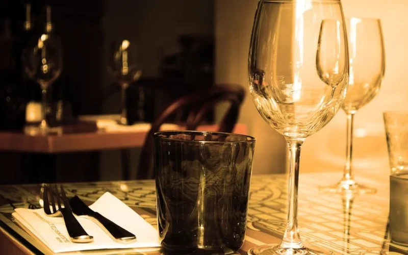 A chilled glass of pale pink rosé wine served with gourmet food in a restaurant.