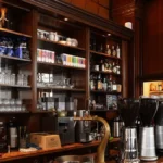 Modern coffee machines creating latte art with steaming milk in a bright café setting.