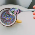 Pouring citrus into blue butterfly pea flower tea creating a purple color transformation.
