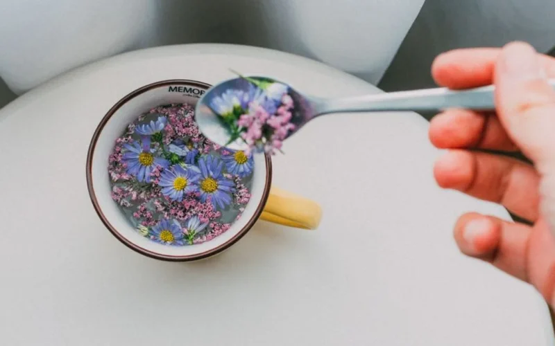 Pouring citrus into blue butterfly pea flower tea creating a purple color transformation.
