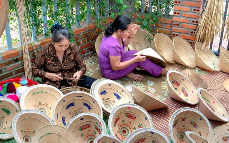 Aerial view of thousands of conical hats arranged in a teapot shape on green hills.