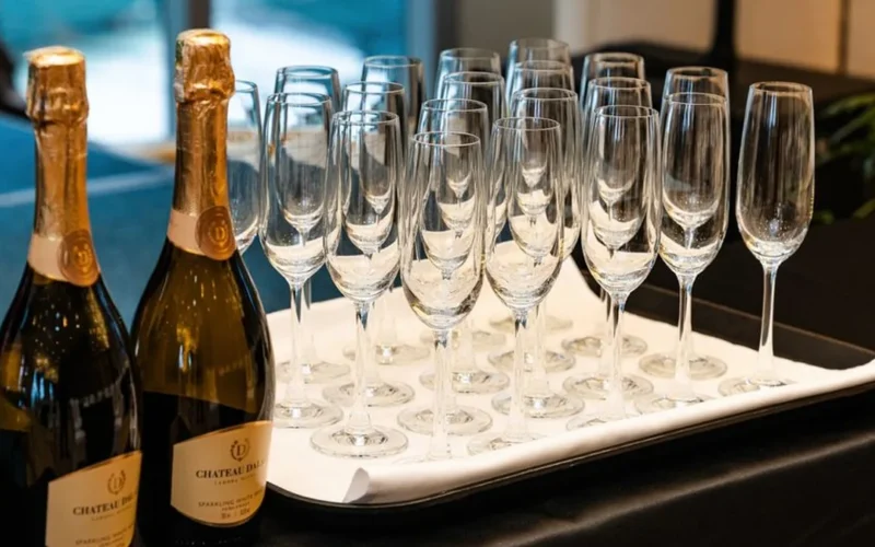 A luxury champagne flute beside a modern glass of Crémant sparkling wine on marble.