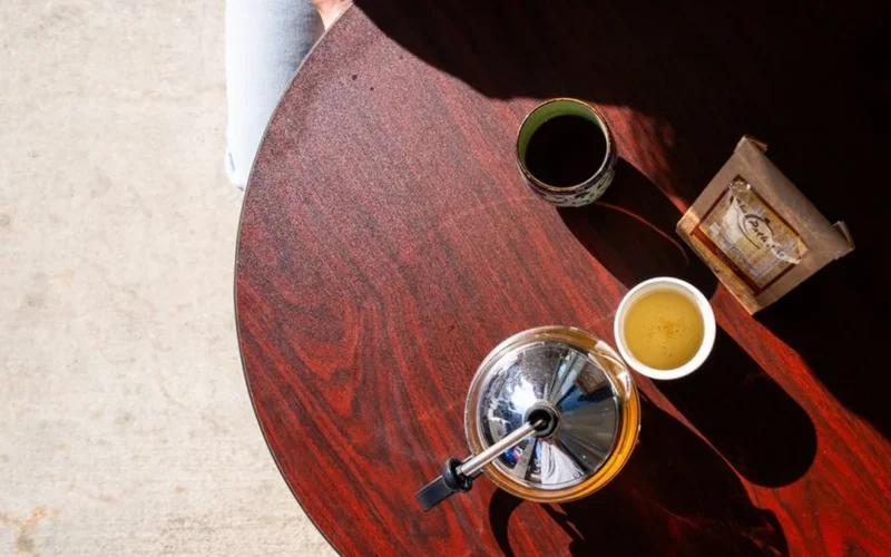 A comparison of a dark cup of coffee and bright green tea.