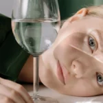 A close-up shot of white Riesling wine being poured into a crystal glass.