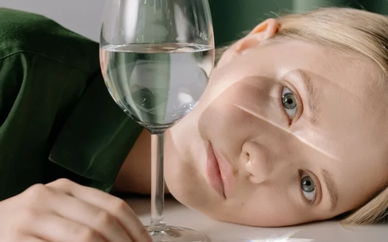 A close-up shot of white Riesling wine being poured into a crystal glass.