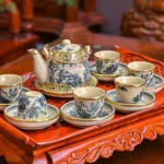 Aged puer tea brick displayed on wooden tray with steaming clay pot and bamboo steamer.