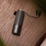 High-end coffee grinder in modern kitchen setting with precise coffee grounds spilling into glass container.