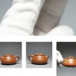 Close-up of a handcrafted reddish Zhuni clay Yixing teapot on a dark stone surface.
