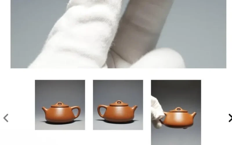 Close-up of a handcrafted reddish Zhuni clay Yixing teapot on a dark stone surface.