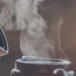 Steaming tea pot with mist rising in a bamboo garden setting, traditional tea ceremony.