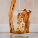 Refreshing ready-to-drink fruit infused iced tea in a glass bottle with ice.