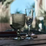 A chilled glass of sparkling Champagne on a white marble tabletop with soft lighting.