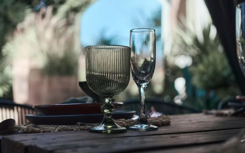 A chilled glass of sparkling Champagne on a white marble tabletop with soft lighting.