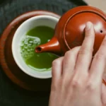 A minimalist tea ceremony setup with matcha bowl and bamboo whisk in soft natural light.