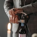 Aged Pinot Noir bottle on rustic table under candlelight, evoking sophistication and depth.