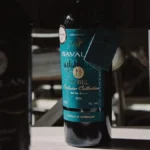 Close up of a wine bottle showing small organic and sustainability certification icons on the label.