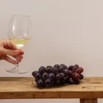 Still white wine in a crystal glass overlooking a sun-drenched Spanish vineyard at sunset.