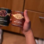 A person holding a caffeinated beverage can showing the nutritional information and ingredients list.