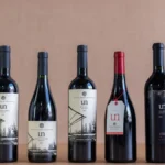 Collection of vintage Napa Valley Cabernet Sauvignon bottles and a poured glass of red wine.