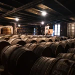 Amber wine fermenting in a glass vessel inside a small rustic workspace.