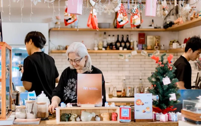 A cafe manager having a professional discussion with baristas behind a coffee shop counter.
